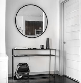 Μεγάλος μαύρος στρογγυλός καθρέφτης στο διάδρομο